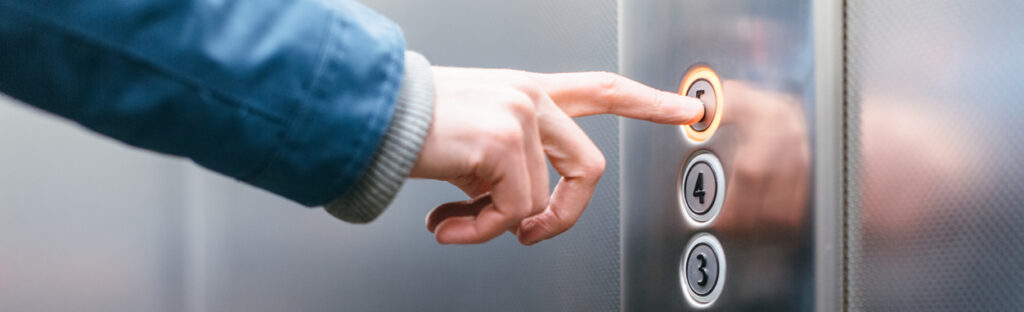 Photo d'une personne qui appuie sur un bouton dans un ascenseur